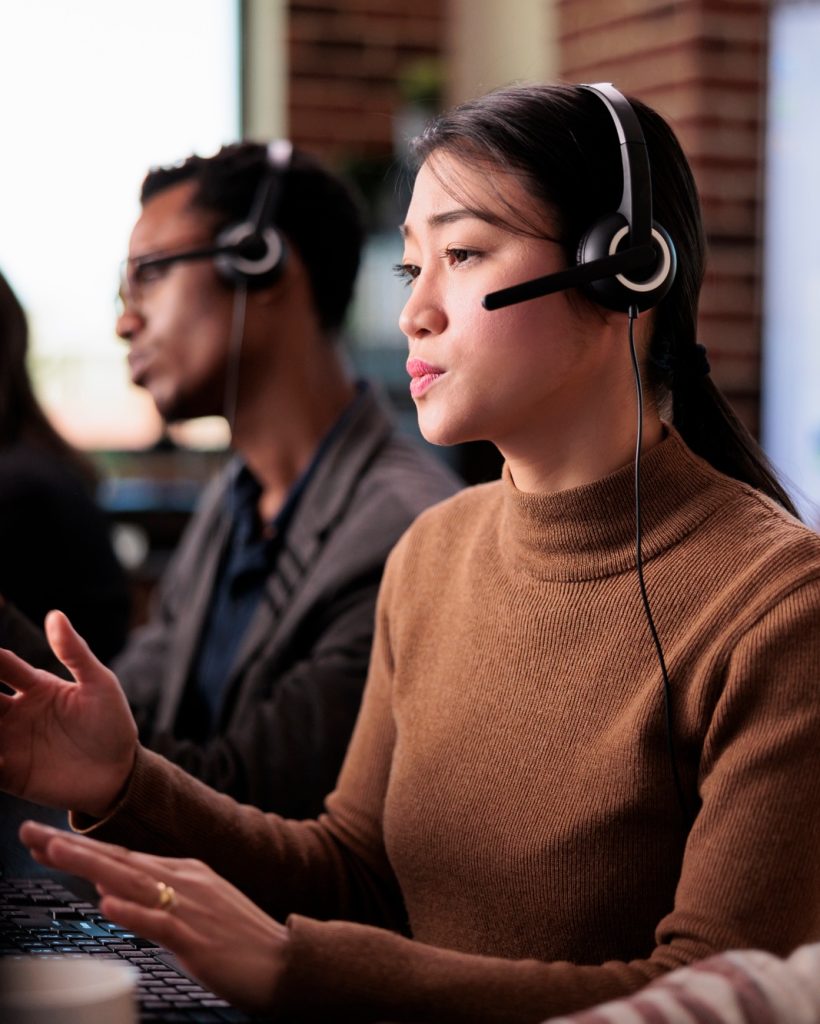 Asian female receptionist working at customer service helpdesk
